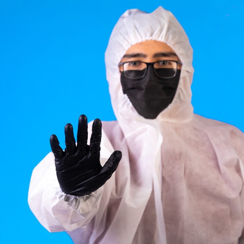 Sanitizer in special preventive uniform and masks on blue background. High quality photo